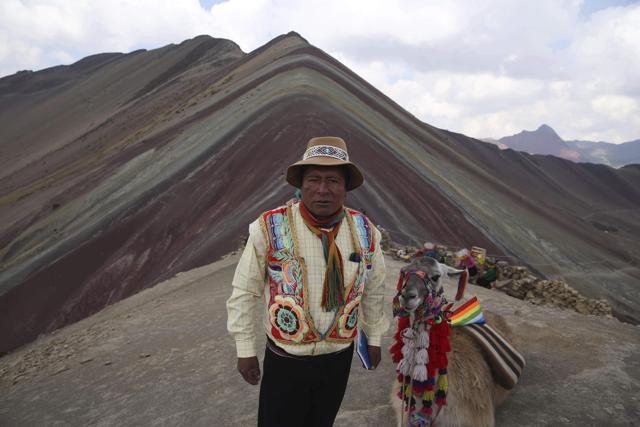 Community leader Gabino Human poses for a photo backdropped by Rainbow Mountain. A surge in tourists comes with a responsibility to be good stewards of the environment and their new guests, says Huaman. (AP) Community leader Gabino Human poses for a photo backdropped by Rainbow Mountain. A surge in tourists comes with a responsibility to be good stewards of the environment and their new guests, says Huaman. (AP)