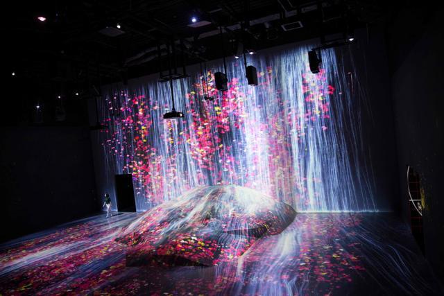 The flower-filled waterfall is the work of Japanese collective teamLab, known internationally for their innovative "digital art". (AFP) The flower-filled waterfall is the work of Japanese collective teamLab, known internationally for their innovative "digital art". (AFP)