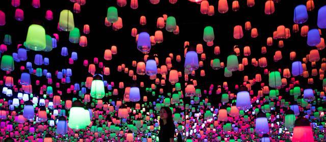 A Japanese member of Teamlab collective walks and poses in a digital installation room with hanging lamps. (AFP) A Japanese member of Teamlab collective walks and poses in a digital installation room with hanging lamps. (AFP)