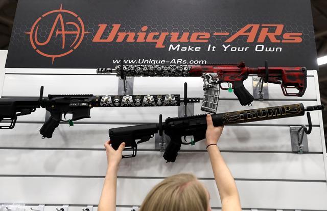 A vendor hangs an AR15 rifle with a custom "Trump - Make America Great Again" hand guard at the Unique ARs booth during the NRA Annual Meeting &amp; Exhibits at the Kay Bailey Hutchison Convention Center on May 5, 2018 in Dallas, Texas. (AFP Photo)