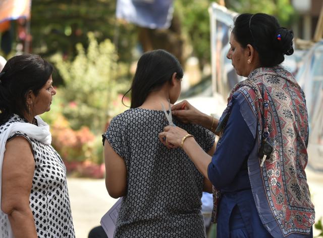 A team of teachers remove a button from the dress of a female candidate while frisking at an exam centre in Bhopal, MP. (Mujeeb Faruqui/HT Photo) A team of teachers remove a button from the dress of a female candidate while frisking at an exam centre in Bhopal, MP. (Mujeeb Faruqui/HT Photo)