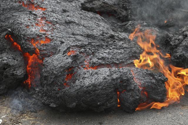 Lava burns across a road in the Leilani Estates subdivision, near Pahoa, Hawaii. (AP Photo)