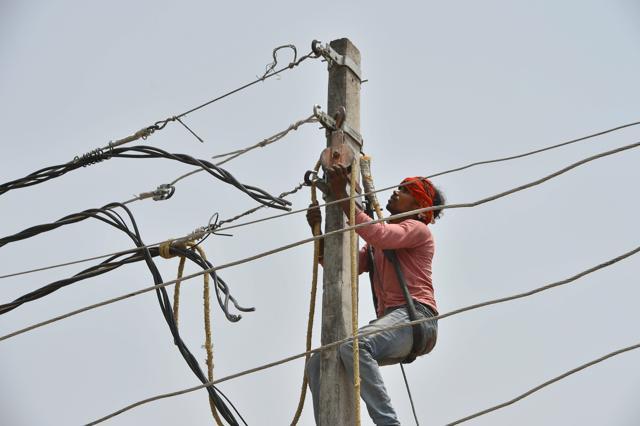 A lineman electric lines, damaged in Wednesday's massive storm, at a village in Agra district on Friday. (PTI Photo) A lineman electric lines, damaged in Wednesday's massive storm, at a village in Agra district on Friday. (PTI Photo)