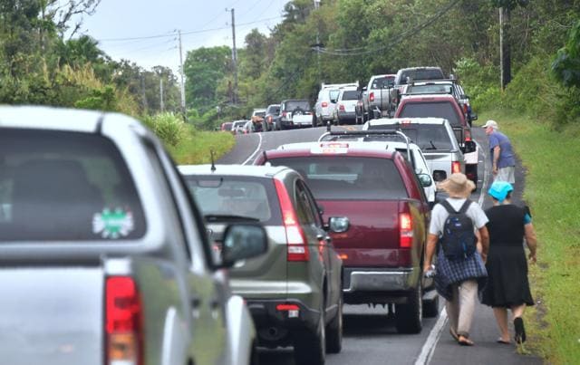 Leilani Estates residents Guineverve and Matthew Underwood walk beside a long convoy of vehicles awaiting re-entry to their homes to gather belongings near the town of Pahoa on Hawaii's Big Island on May 7, 2018, after the residents were forced to evacuate following recent earthquakes and concern over toxic sulphur dioxide. (AFP Photo) Leilani Estates residents Guineverve and Matthew Underwood walk beside a long convoy of vehicles awaiting re-entry to their homes to gather belongings near the town of Pahoa on Hawaii's Big Island on May 7, 2018, after the residents were forced to evacuate following recent earthquakes and concern over toxic sulphur dioxide. (AFP Photo)