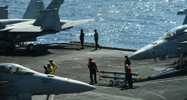 Sailors prepare to arm fighter jets of missiles on the flight deck during a routine training aboard US aircraft carrier Theodore Roosevelt in the South China sea. (AFP Photo) Sailors prepare to arm fighter jets of missiles on the flight deck during a routine training aboard US aircraft carrier Theodore Roosevelt in the South China sea. (AFP Photo)