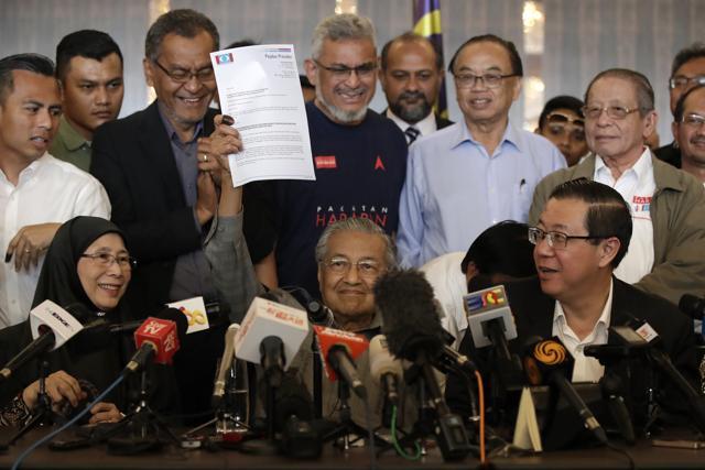 Mahathir Mohamad, centre, shows an endorsement letter next to president of Justice Party Wan Azizah, left, and general secretary of Democratic Action Party Lim Guan Eng, right, during a press conference at a hotel in Kuala Lumpur, Malaysia, on Thursday. (AP Photo) Mahathir Mohamad, centre, shows an endorsement letter next to president of Justice Party Wan Azizah, left, and general secretary of Democratic Action Party Lim Guan Eng, right, during a press conference at a hotel in Kuala Lumpur, Malaysia, on Thursday. (AP Photo)