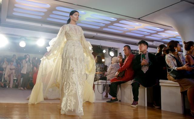 A model walks on the catwalk displaying designs by Amato Couture. (AFP) A model walks on the catwalk displaying designs by Amato Couture. (AFP)