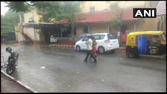 Voters take shelter at polling station number 185 in Hubli due to rains. (ANI/Twitter) Voters take shelter at polling station number 185 in Hubli due to rains. (ANI/Twitter)