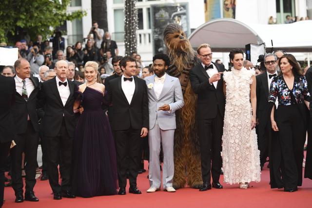 Actor Woody Harrelson, from left, director Ron Howard, actors Emilia Clarke, Alden Ehrenreich, Donald Glover, a person dressed as the character Chewbacca, Paul Bettany, Phoebe Waller-Bridge, and producer Kathleen Kennedy pose for photographers upon arrival at the premiere of the film 'Solo: A Star Wars Story' at the 71st international film festival, Cannes. (Arthur Mola/Invision/AP) Actor Woody Harrelson, from left, director Ron Howard, actors Emilia Clarke, Alden Ehrenreich, Donald Glover, a person dressed as the character Chewbacca, Paul Bettany, Phoebe Waller-Bridge, and producer Kathleen Kennedy pose for photographers upon arrival at the premiere of the film 'Solo: A Star Wars Story' at the 71st international film festival, Cannes. (Arthur Mola/Invision/AP)