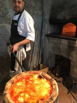 A chef from Belmond Hotel Caruso preparing the perfect pizza