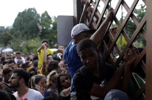 Fans gather outside the training center in Granja Comary, Teresopolis, Brazil as they try to enter the ground where the Brazil team was present. (REUTERS)