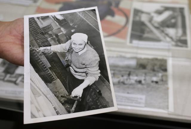 Sue Wilkins holds a 1945 newspaper photograph that shows Fern Corbett, 24, working as a window washer 10 floors above a Minneapolis street during World War II. Corbett worked as her company's stenographer before filling in as a window washer due to the absence of male workers during the war. (AP) Sue Wilkins holds a 1945 newspaper photograph that shows Fern Corbett, 24, working as a window washer 10 floors above a Minneapolis street during World War II. Corbett worked as her company's stenographer before filling in as a window washer due to the absence of male workers during the war. (AP)
