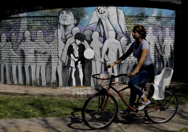 In this April 18, 2018 photo, a woman cycles past Lionel Messi's school "Escuela General Las Heras" primary school in Rosario, Argentina. The mural featuring Messi was painted by the school's students and teachers with the help of local artist Ruben Perez Barrios. (AP) In this April 18, 2018 photo, a woman cycles past Lionel Messi's school "Escuela General Las Heras" primary school in Rosario, Argentina. The mural featuring Messi was painted by the school's students and teachers with the help of local artist Ruben Perez Barrios. (AP)