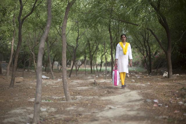 Monika Ghosh walks the lane she travels to work. Monika leaves work by 6 pm and is picked up by her husband to avoid walking the the track alone at night. (Photographer: Ruhani Kaur/Bloomberg) Monika Ghosh walks the lane she travels to work. Monika leaves work by 6 pm and is picked up by her husband to avoid walking the the track alone at night. (Photographer: Ruhani Kaur/Bloomberg)