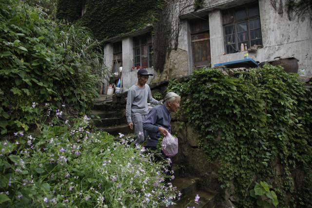 Lin Fazhen, 60, left, is one of the five residents left from the 3,000 that once lived in the village. (AP) Lin Fazhen, 60, left, is one of the five residents left from the 3,000 that once lived in the village. (AP)