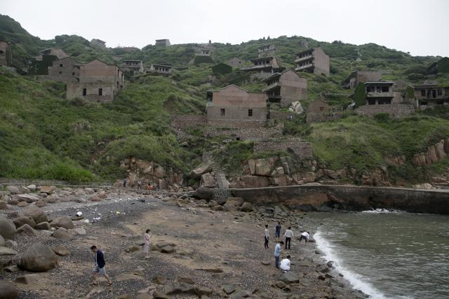 Ivy cloaks some buildings completely but on many Houtouwan houses, beautiful roof tiles still gleam and broken verandas offer majestic views of the stormy sea. (AP) Ivy cloaks some buildings completely but on many Houtouwan houses, beautiful roof tiles still gleam and broken verandas offer majestic views of the stormy sea. (AP)
