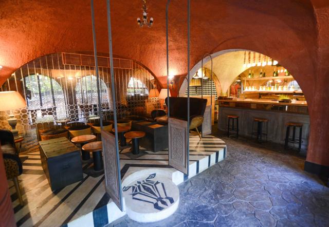 The dining section, with its soft lighting, mustard-brown walls and arching pillars, has a cavern-like feel.
