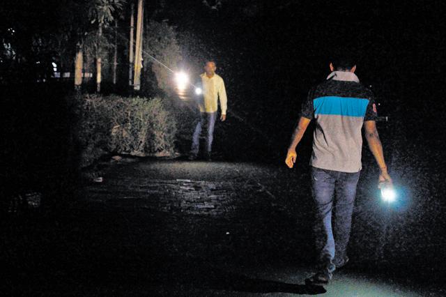 People use their mobile flashlights while walking on the road. (Yogendra Kumar/HT Photo) People use their mobile flashlights while walking on the road. (Yogendra Kumar/HT Photo)