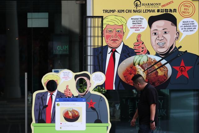 A man walks by cut-outs in the likeness of US President Donald Trump, left, and North Korea's Leader Kim Jong Un outside a restaurant in Singapore, on Saturday. (Bloomberg) A man walks by cut-outs in the likeness of US President Donald Trump, left, and North Korea's Leader Kim Jong Un outside a restaurant in Singapore, on Saturday. (Bloomberg)