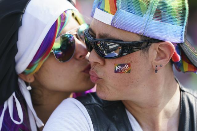 Tammy Kronebusch, right, president of the Out Riders Women's Motorcycle Club, kisses her passenger Veronica Simbulan, left, before they lead the Capital Pride Parade in Washington on June 9. (AP Photo) Tammy Kronebusch, right, president of the Out Riders Women's Motorcycle Club, kisses her passenger Veronica Simbulan, left, before they lead the Capital Pride Parade in Washington on June 9. (AP Photo)