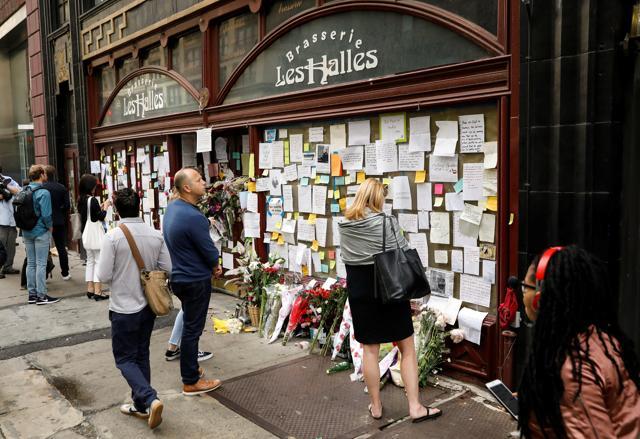 People look at tributes to chef and television personality Anthony Bourdain outside Brasserie Les Halles in New York. (REUTERS)
