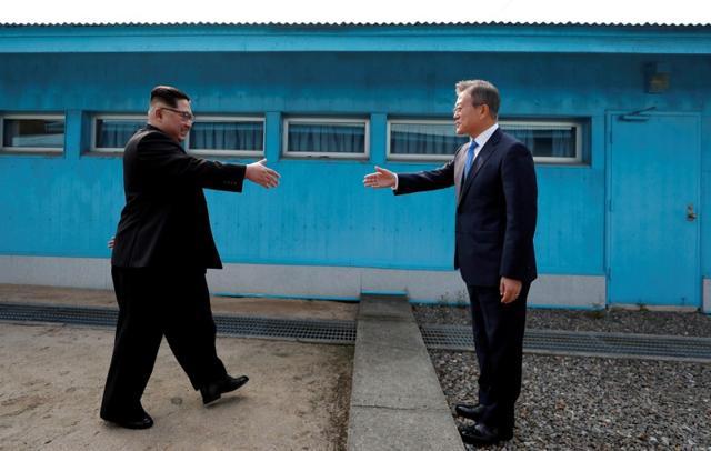 South Korean president Moon Jae-in and North Korean leader Kim Jong Un about to shake hands on their first ever meeting at the truce village of Panmunjom inside the demilitarized zone separating the two Koreas, South Korea, on April 27, 2018. (Reuters)