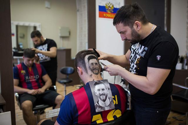 Serbian hairdresser Mario Hvala creates a hair tattoo showing the portrait of Argentinian football player Lionel Messi on the head of a football fan in Novi Sad, Serbia. (AFP)
