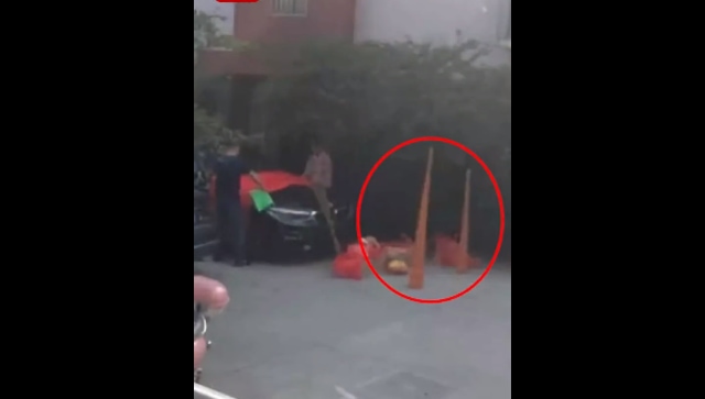 A screenshot of the video shows a man, his wife placing offerings in utensils and setting up giant incense sticks (Miaopai.com/Screengrab)