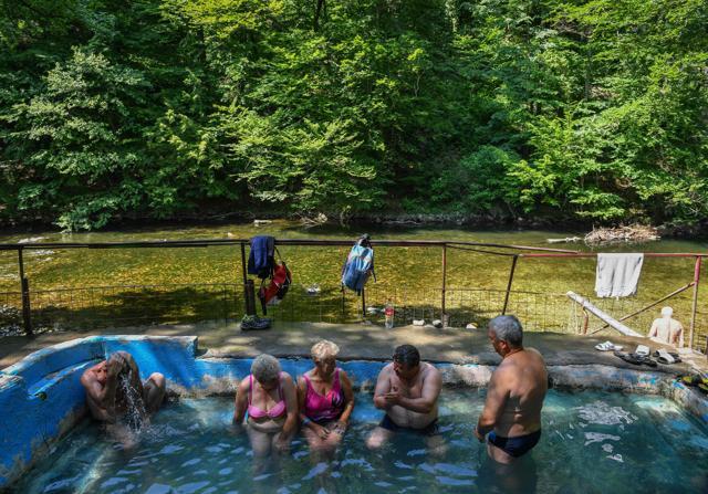 Tourists take a bath at an improvised spa constructed by a local resident close to Baile Herculane, southwestern Romani. (AFP) Tourists take a bath at an improvised spa constructed by a local resident close to Baile Herculane, southwestern Romani. (AFP)