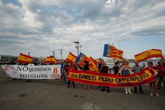 People hold a banner reading 'We don't want refugees' during a demonstration called by the far-right political party Espana 2000 (E-2000) against the arrival of the Aquarius rescue ship in Valencia. (AFP Photo)