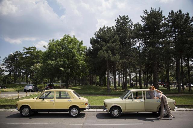 Jovana Stojiljkovic, manager of the Yugotour agency, checks a Yugoslav era popular car Zastava 101 in Belgrade. (AFP)