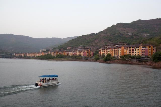 A boat travels across Dasve Lake as residential buildings stand along the promenade in Lavasa on May 12. (Bloomberg) A boat travels across Dasve Lake as residential buildings stand along the promenade in Lavasa on May 12. (Bloomberg)