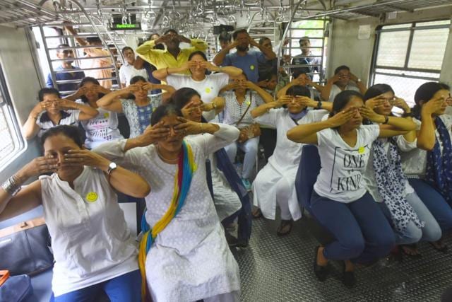 Yoga teachers from different schools perform yoga with commuters inside a local train on Mumbai’s western line. (Pratik Chorge/HT Photo)