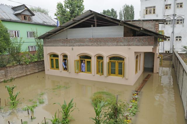 People look out of the windows of an inundated house in Srinagar on Saturday. (Waseem Andrabi / HT Photo) People look out of the windows of an inundated house in Srinagar on Saturday. (Waseem Andrabi / HT Photo)