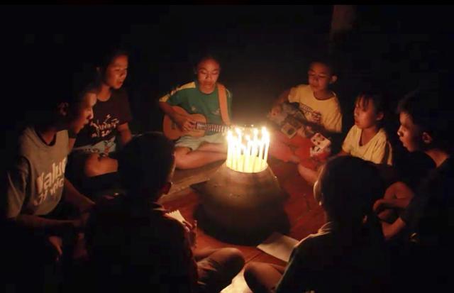 A group of young children sit around candles and play a song at a school in Buriram, eastern Thailand, in support for the missing soccer team and their coach in a flooded cave in the north. (AP/Videograb) A group of young children sit around candles and play a song at a school in Buriram, eastern Thailand, in support for the missing soccer team and their coach in a flooded cave in the north. (AP/Videograb)