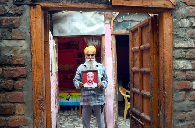 Jotu’s father holds up his photo at his home. (Sameer Sehgal/HT Photo) Jotu’s father holds up his photo at his home. (Sameer Sehgal/HT Photo)