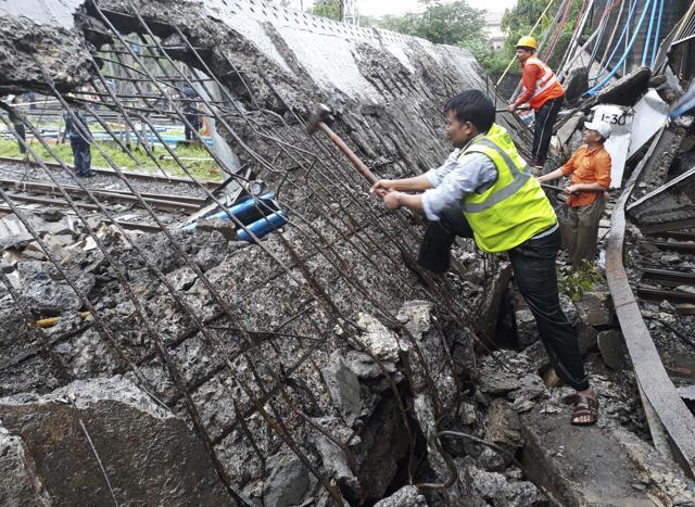 Rescuers work at the site of a pedestrian bridge that collapsed at a train station in Mumbai, on Tuesday. (AP Photo) Rescuers work at the site of a pedestrian bridge that collapsed at a train station in Mumbai, on Tuesday. (AP Photo)