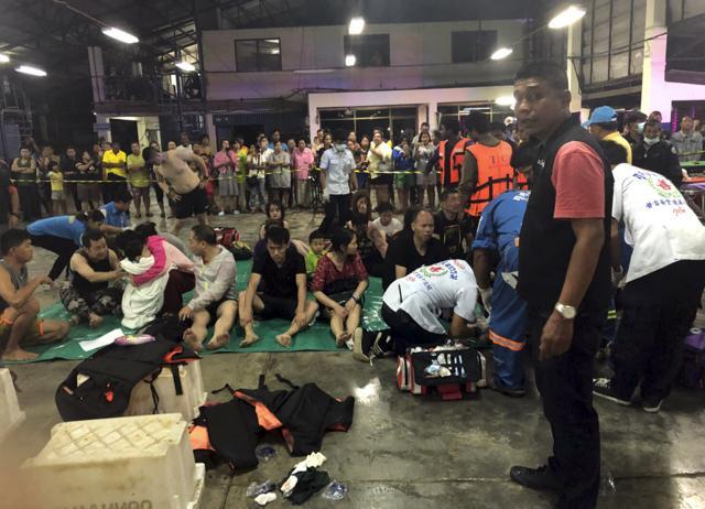 In this photo released by the Thailand Royal Police, rescued tourists from a boat that sank rest on a pier Thursday, July 5, 2018, on the island of Phuket, southern Thailand. (AP) In this photo released by the Thailand Royal Police, rescued tourists from a boat that sank rest on a pier Thursday, July 5, 2018, on the island of Phuket, southern Thailand. (AP)