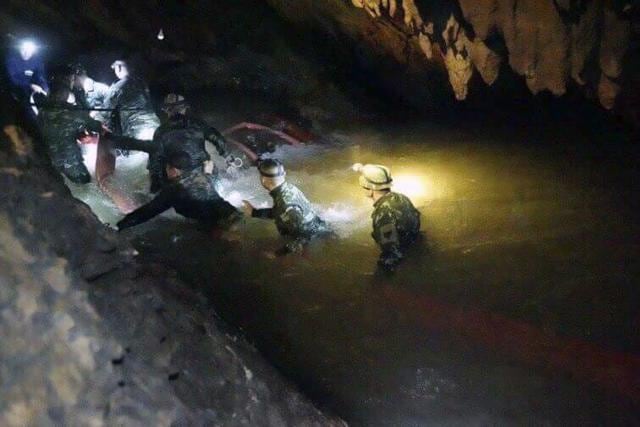 Thai rescue teams wade through water to reach 12 boys and their soccer coach stranded inside. (AP/Tham Luang Rescue Operation Center)