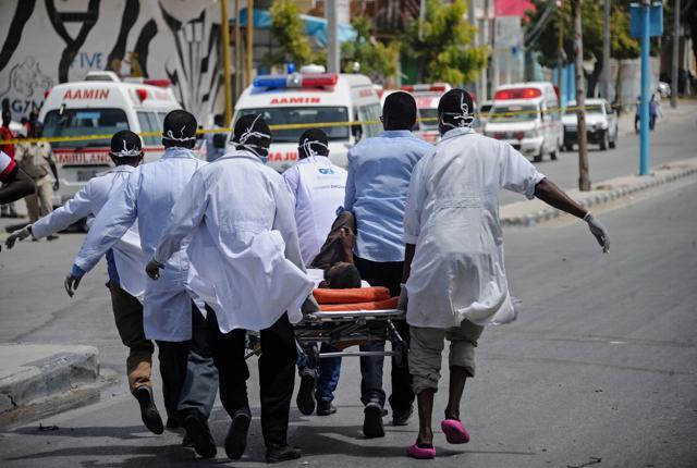 Paramedics use a stretcher to carry the body of victim from the site of an explosion in Mogadishu on July 7, 2018. (AFP) Paramedics use a stretcher to carry the body of victim from the site of an explosion in Mogadishu on July 7, 2018. (AFP)