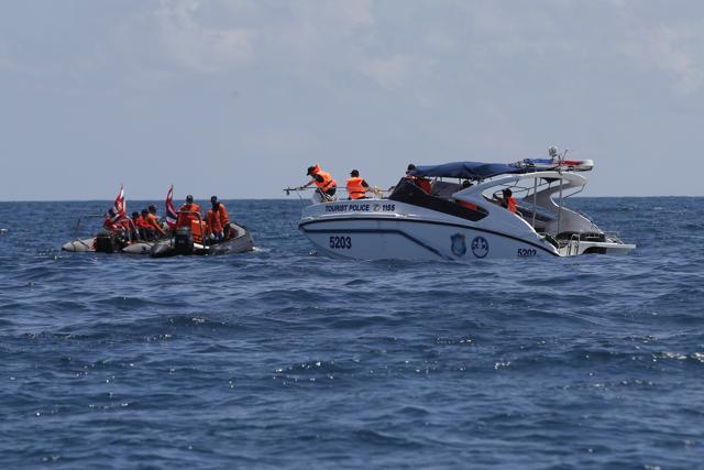 Thai rescue divers and a tourist police boat are seen during a search mission for missing passengers from a capsized tourist boat in the water off Phuket. (AP Photo) Thai rescue divers and a tourist police boat are seen during a search mission for missing passengers from a capsized tourist boat in the water off Phuket. (AP Photo)