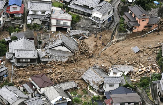 Houses are damaged by mudslide following heavy rains in Kure city, Hiroshima prefectur. (AP Photo) Houses are damaged by mudslide following heavy rains in Kure city, Hiroshima prefectur. (AP Photo)