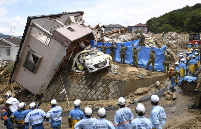Rescuers conduct a search operation for missing persons in Kumano town, Hiroshima prefecture. (AP Photo)