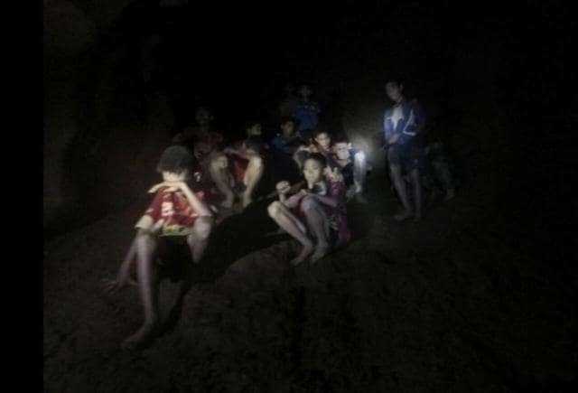 This Monday, July 2, 2018, file photo provided by Tham Luang Rescue Operation Center shows a group of Thai youth soccer players and their coach as they were found in a partially flooded cave in Mae Sai, Chiang Rai province, northern Thailand. (AP)