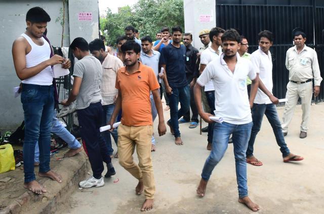 Aspirants, most of them bare foot, and some without shirts, come out after appearing in teh constable recruitment exam in Jaipur on Saturday. (Prabhakar Sharma/HT Photo)