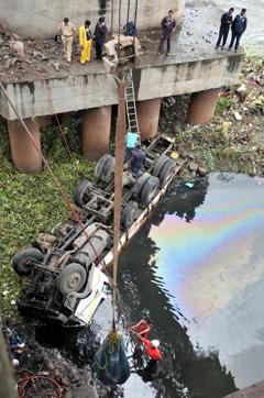 The truck got stuck in the sludge in the river after it fell off the bridge. (HT PHOTO)