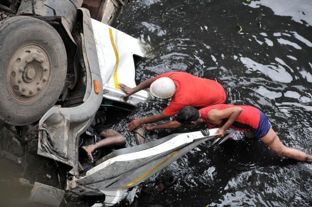Fire brigade officials fish out the bodies of the truck driver and cleaner from the vehicle. (HT PHOTO)