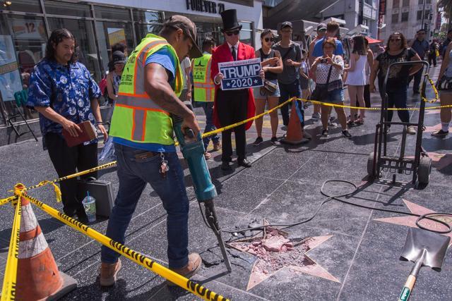 A worker removes the remains of the Star of US President Donald J Trump on the Hollywood Walk of Fame after it was destroyed by a vandal in the early morning hours on July 25. (AFP)