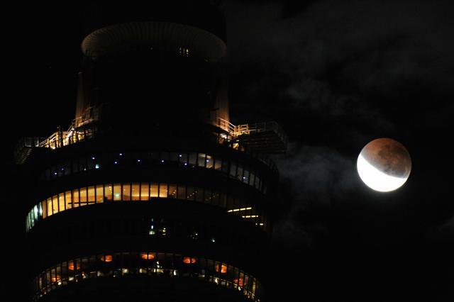 The moon enters the earth's shadow to begin a partial lunar eclipse prior to a total lunar eclipse, next to Sydney tower in Australia. (AFP) The moon enters the earth's shadow to begin a partial lunar eclipse prior to a total lunar eclipse, next to Sydney tower in Australia. (AFP)
