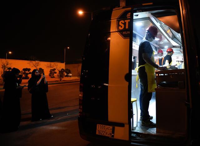 A picture taken on July 5, 2018, shows Saudi women filming the food truck "One Way Burger" while waiting for their order at a main street in the capital Riyadh. (AFP) A picture taken on July 5, 2018, shows Saudi women filming the food truck "One Way Burger" while waiting for their order at a main street in the capital Riyadh. (AFP)